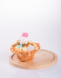 Close-up of cake on table against white background