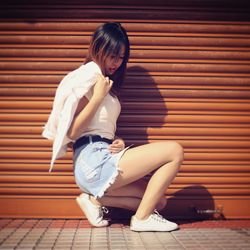 Full length of woman sitting on floor