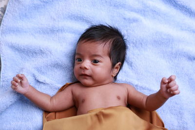 Portrait of cute baby lying on bed