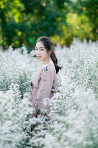 Young woman standing on flowering plants