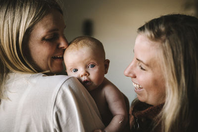 Smiling mothers holding newborn baby