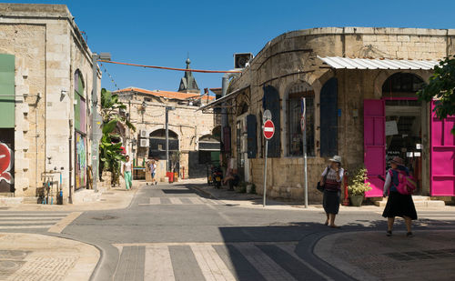 People walking on street against buildings in city