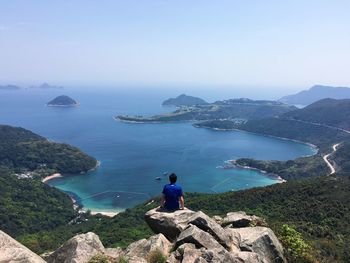 Man sitting on rock at seaside