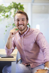 Portrait of smiling man sitting on table