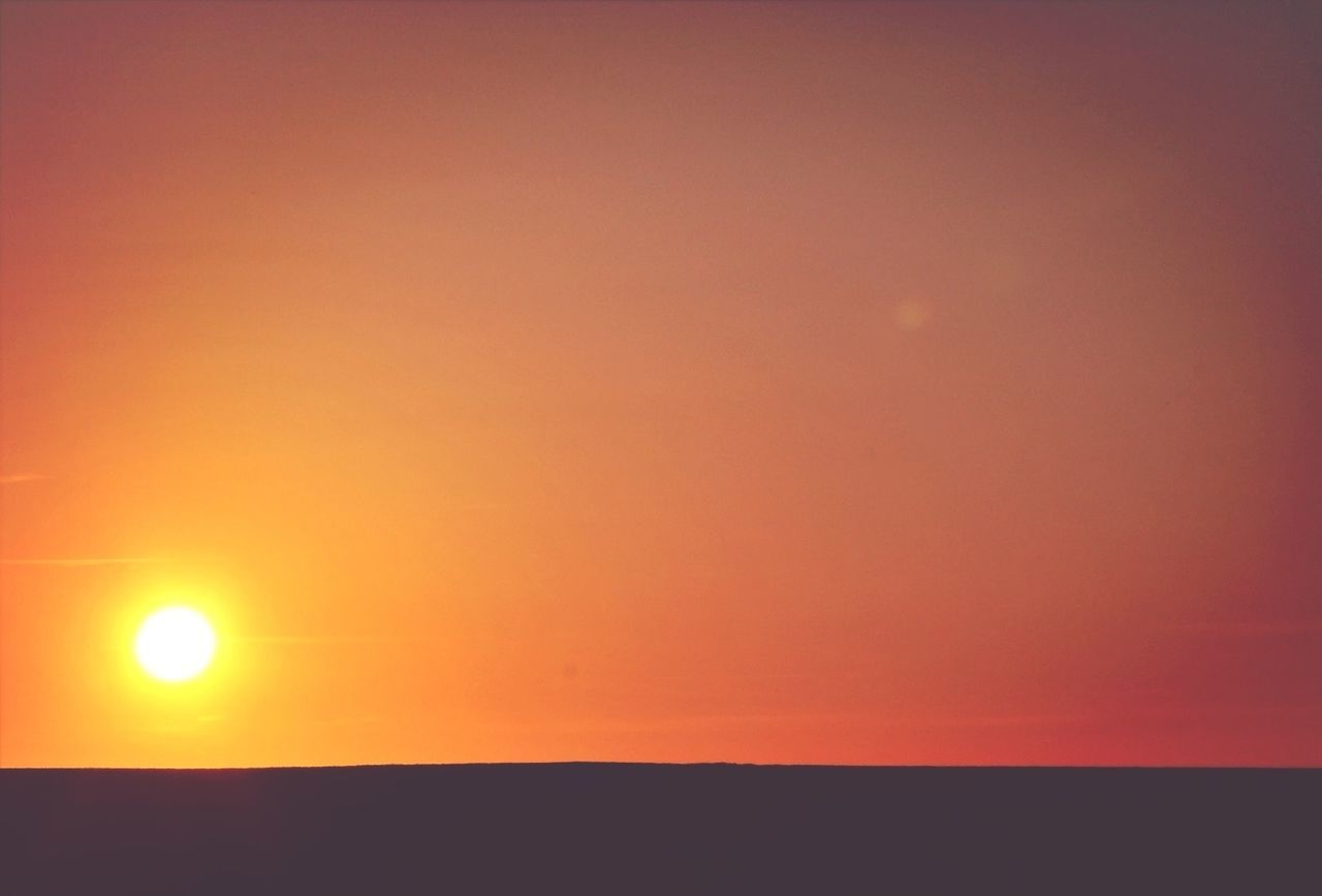 sunset, orange color, scenics, copy space, beauty in nature, tranquil scene, tranquility, sun, silhouette, idyllic, nature, landscape, sky, sunlight, no people, outdoors, clear sky, horizon over land, remote, field