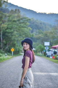 Side view of woman standing on road