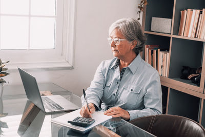 Man using mobile phone while sitting on table