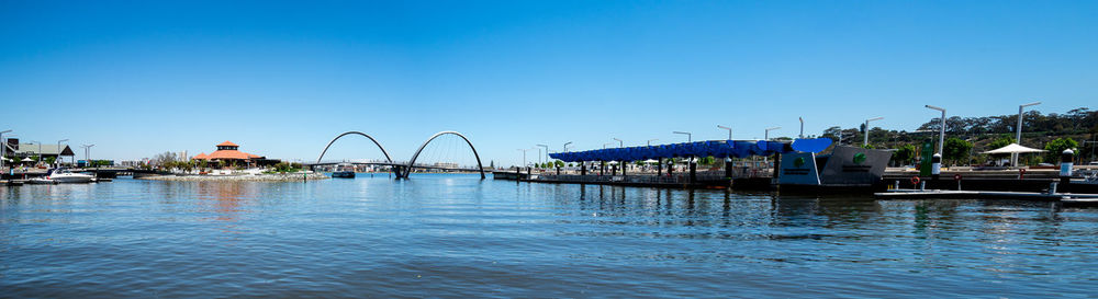 Bridge over river against clear blue sky