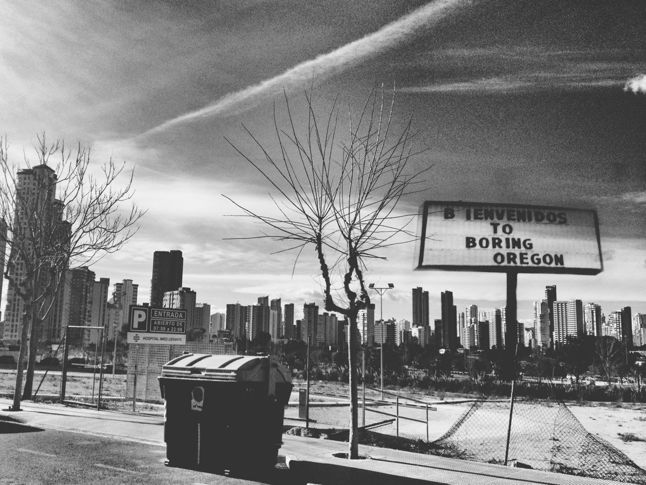 text, building exterior, built structure, architecture, city, sky, western script, communication, tree, day, cloud - sky, outdoors, no people, information sign, cityscape, empty, road, sign, cloud, street