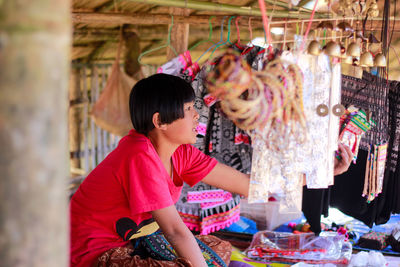 Girl selling various objects at market stall