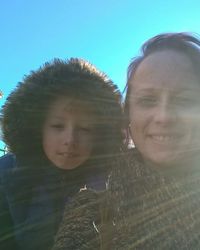 Portrait of happy mother and daughter against clear sky