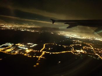 Aerial view of illuminated cityscape against sky at night