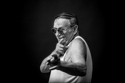 Portrait of shirtless man against black background