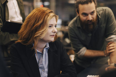 Businesswoman and businessman staring at office