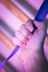 Cropped hand holding strap in gym