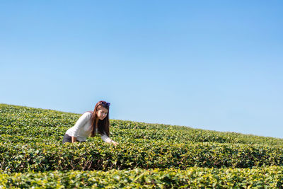 Woman standing on field against clear sky