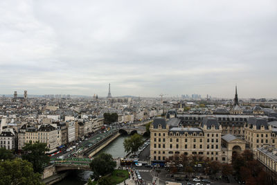 High angle view of city buildings against cloudy sky