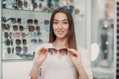 Portrait of a smiling young woman standing in store