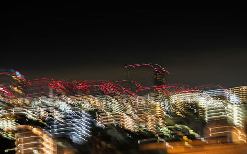 Low angle view of light trails against sky at night