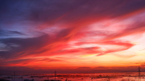 Scenic view of sea against dramatic sky during sunset