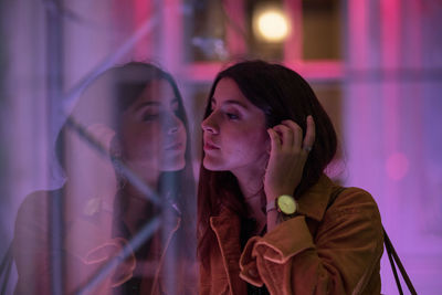 Young woman looking through glass