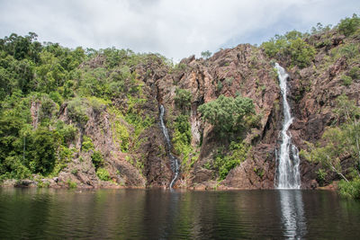 Scenic view of waterfall against sky