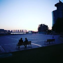 People in city against clear blue sky