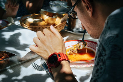 Midsection of man holding ice cream in restaurant