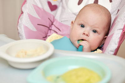 High angle view of cute baby girl eating food