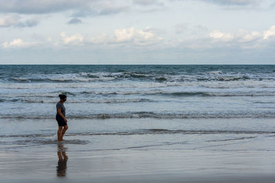 Man standing on beach against sky