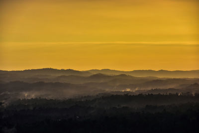 Scenic view of landscape against orange sky