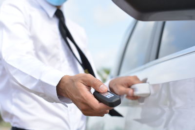 Midsection of man using mobile phone