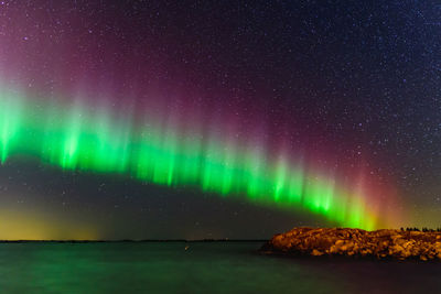 Scenic view of illuminated sky over sea