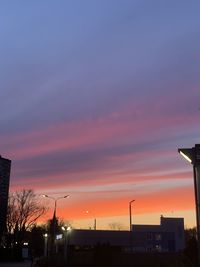 Silhouette buildings against sky at sunset