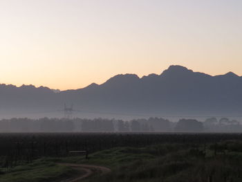 Scenic view of field against clear sky during sunset