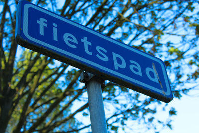 Low angle view of road sign against trees