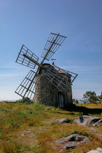 Traditional windmill on field against sky