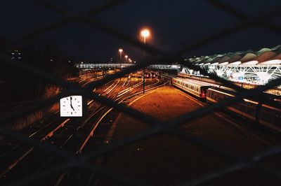 Illuminated railroad tracks against sky at night