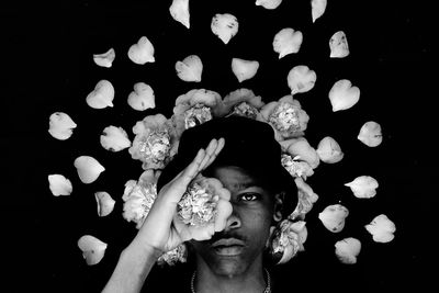 Close-up portrait of young woman against black background