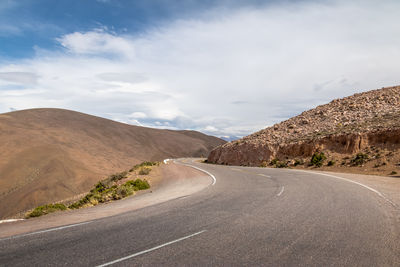 Road by mountain against sky