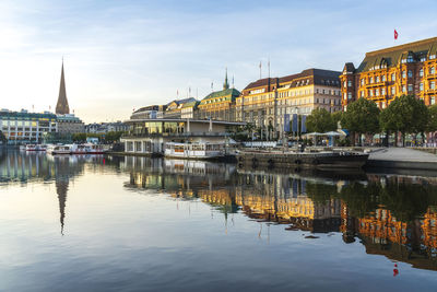 Boats moored in binnenalster lake near buildings, hamburg, germany