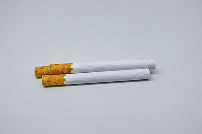 Close-up of cigarette smoking against white background