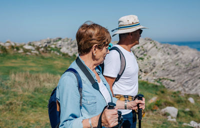 Friends standing on land against sky