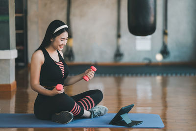 Portrait of young woman exercising in gym