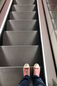 Low section of man standing on escalator