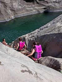 Women wearing life jacket on rock