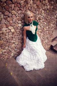 Portrait of a young woman against wall