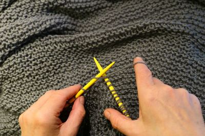 Close-up of cropped woman hands knitting wool