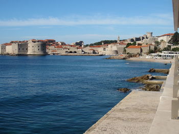 Seascape scene europe across ocean blue sea water from swimming walkway to historic castle and town