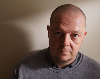 Close-up portrait of a man against wall